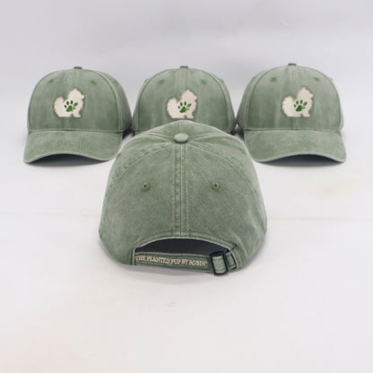 Three sage green baseball caps with a white and green fluffy dog patch and paw print on the front, displayed on a white background with one cap shown from the back.